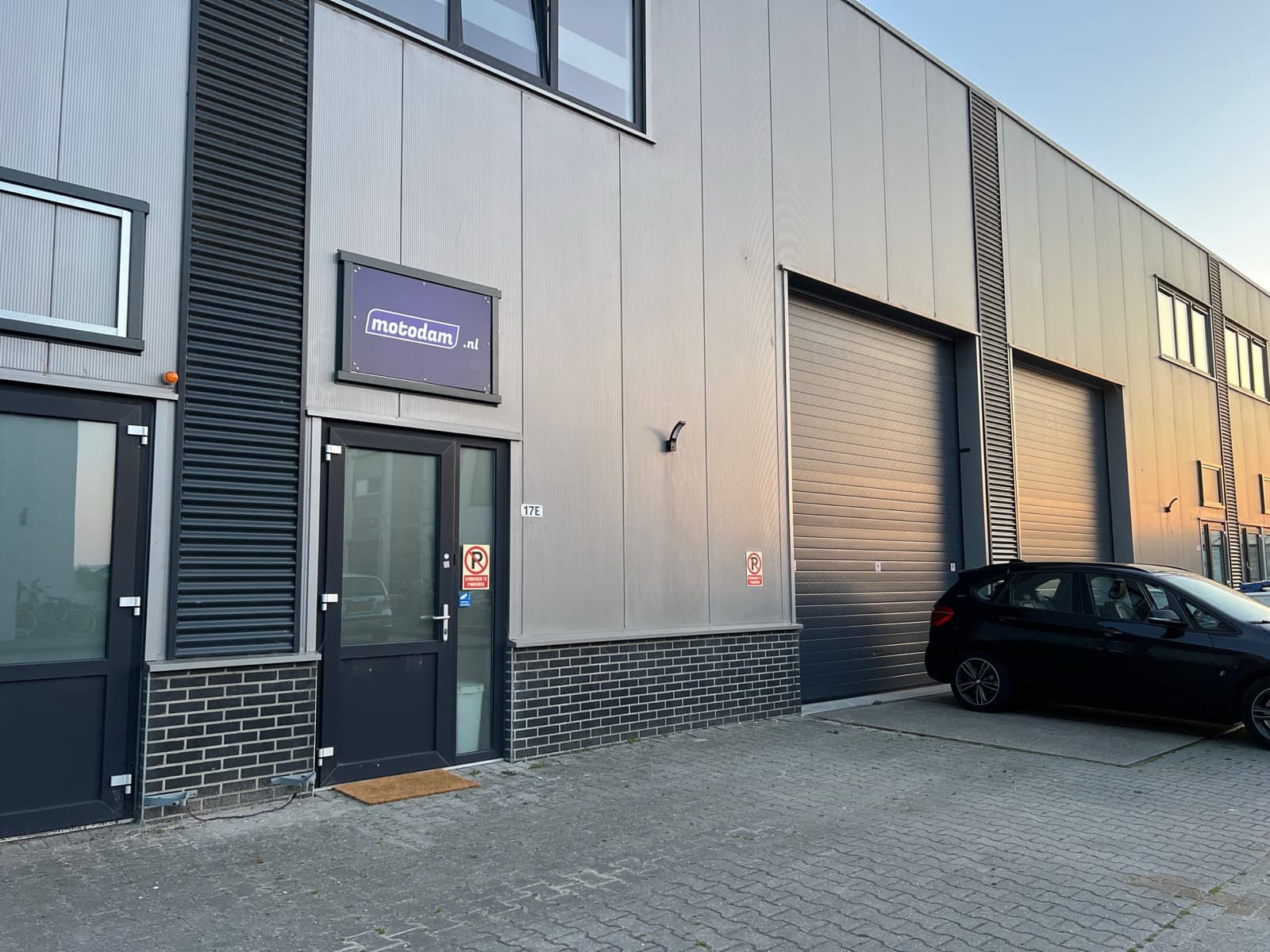 De ingang van Leeuwesteyn Automotive op Noorddammerweg 17E: grijze bedrijfsunit met het bord van Leeuwesteyn Automotive boven de deur